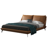 Ardelle Bed featuring smooth caramel vegan leather and a gently curved padded headboard in a modern bedroom setting.