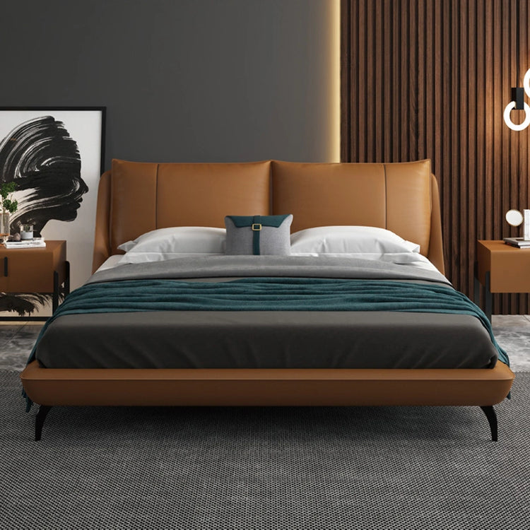 Ardelle Bed in caramel vegan leather with curved headboard and modern decor accents.